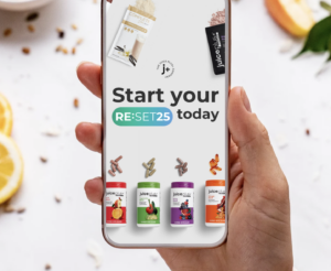 Hand holding a phone with juice plus capsule bottles on it